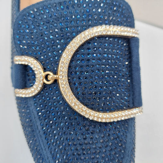 Close-up of the diamante glitter and gold metal decor on women's navy loafers, highlighting their stylish accents in London.