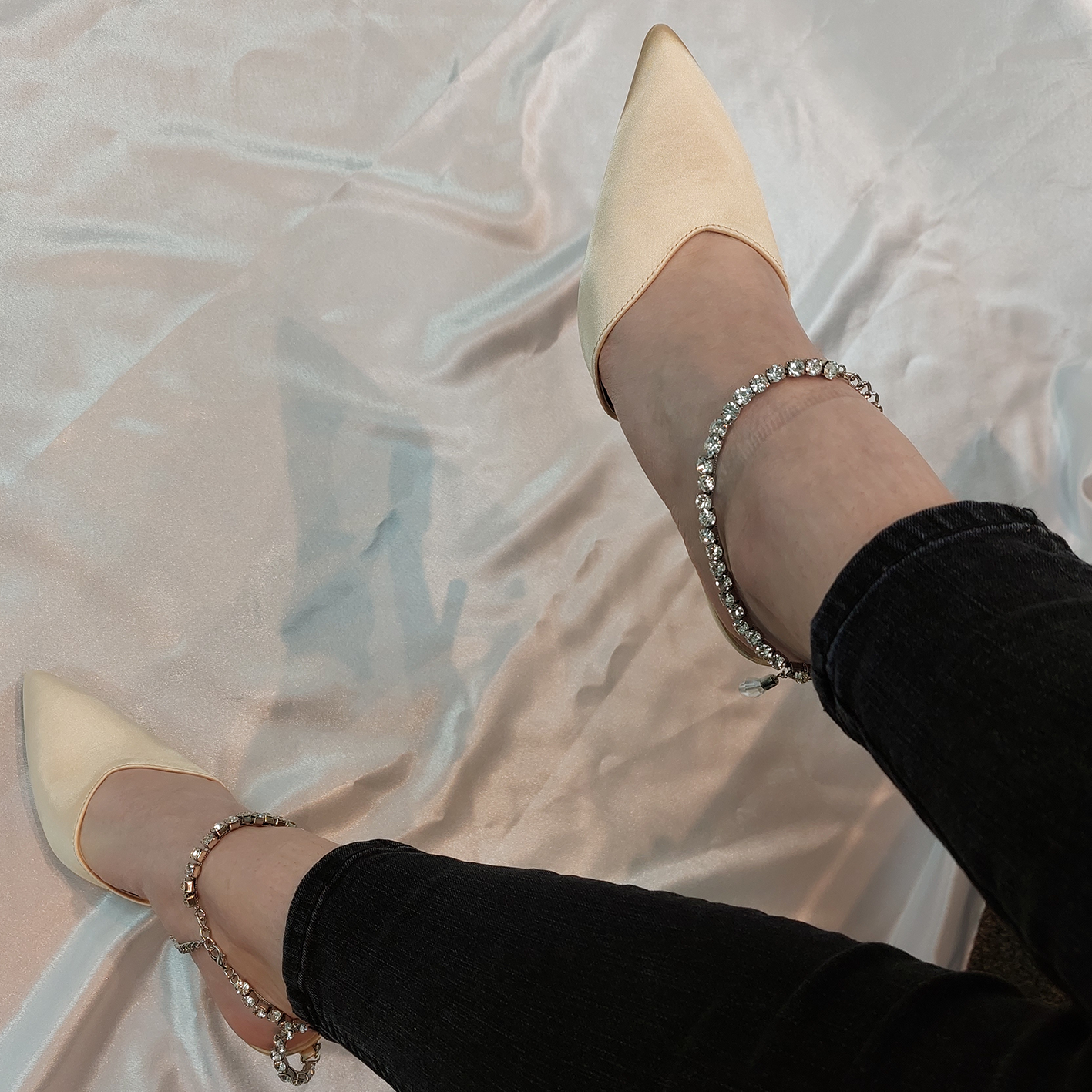 Woman's foot wearing stylish Celestial satin court shoes with diamante ankle chain in beige, a fashionable choice for London events from DeepsLondon.