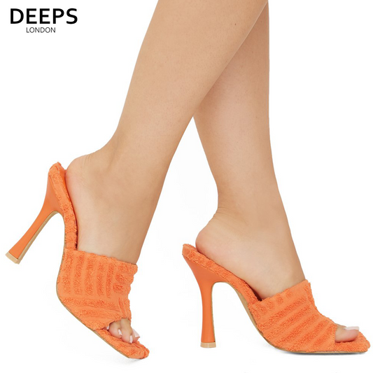 Woman's foot wearing stylish Laila towel fabric mule heels in orange, a fashionable and comfortable choice for London days and evenings from DeepsLondon.