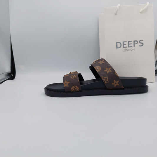 Side view of stylish brown print double buckle flat slider sandals for women.
