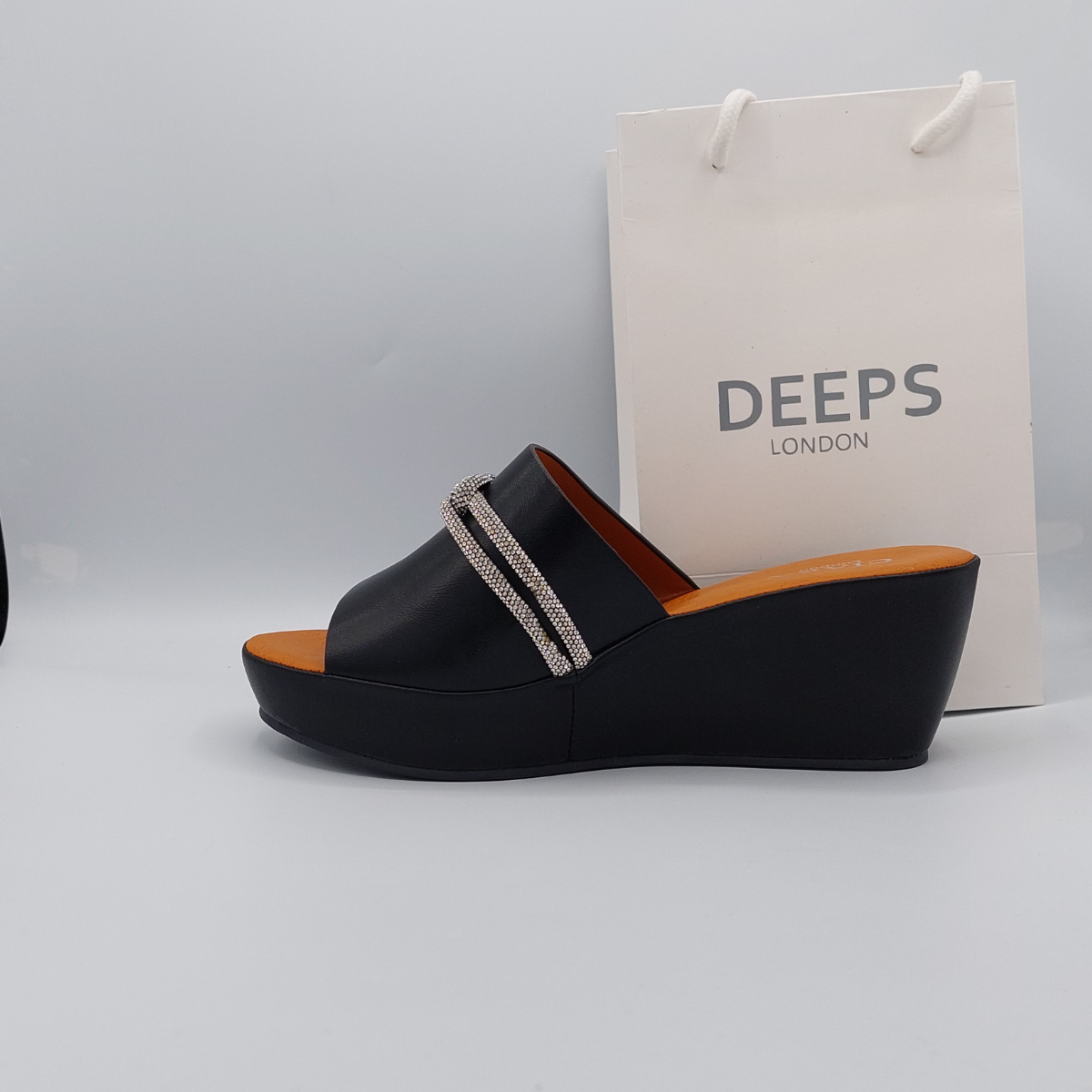 Woman's foot wearing stylish Carey open toe diamante wedge platform mule slider sandal in black, a fashionable and glamorous choice for London summer events from DeepsLondon.