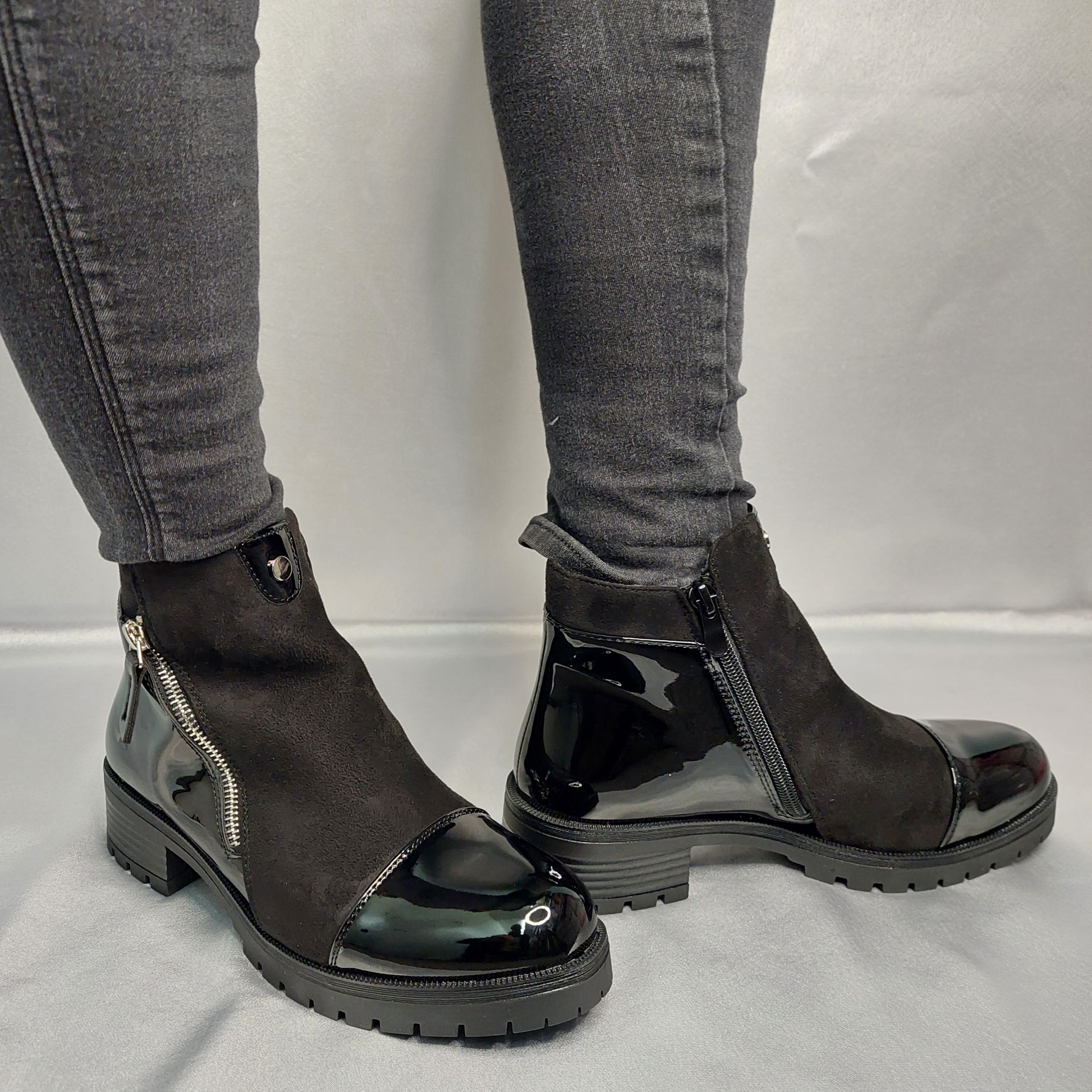 Close-up of the black suede and patent leather combination and the zip pattern on women's chunky Chelsea boots, highlighting their unique and fashionable features in London.