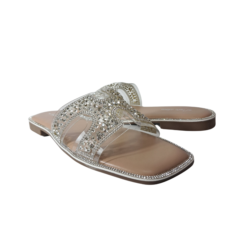 Close-up of the diamante embellishments and cut-out straps on women's flat summer sandals in silver, emphasizing the subtle sparkle and intricate design, London summer footwear.