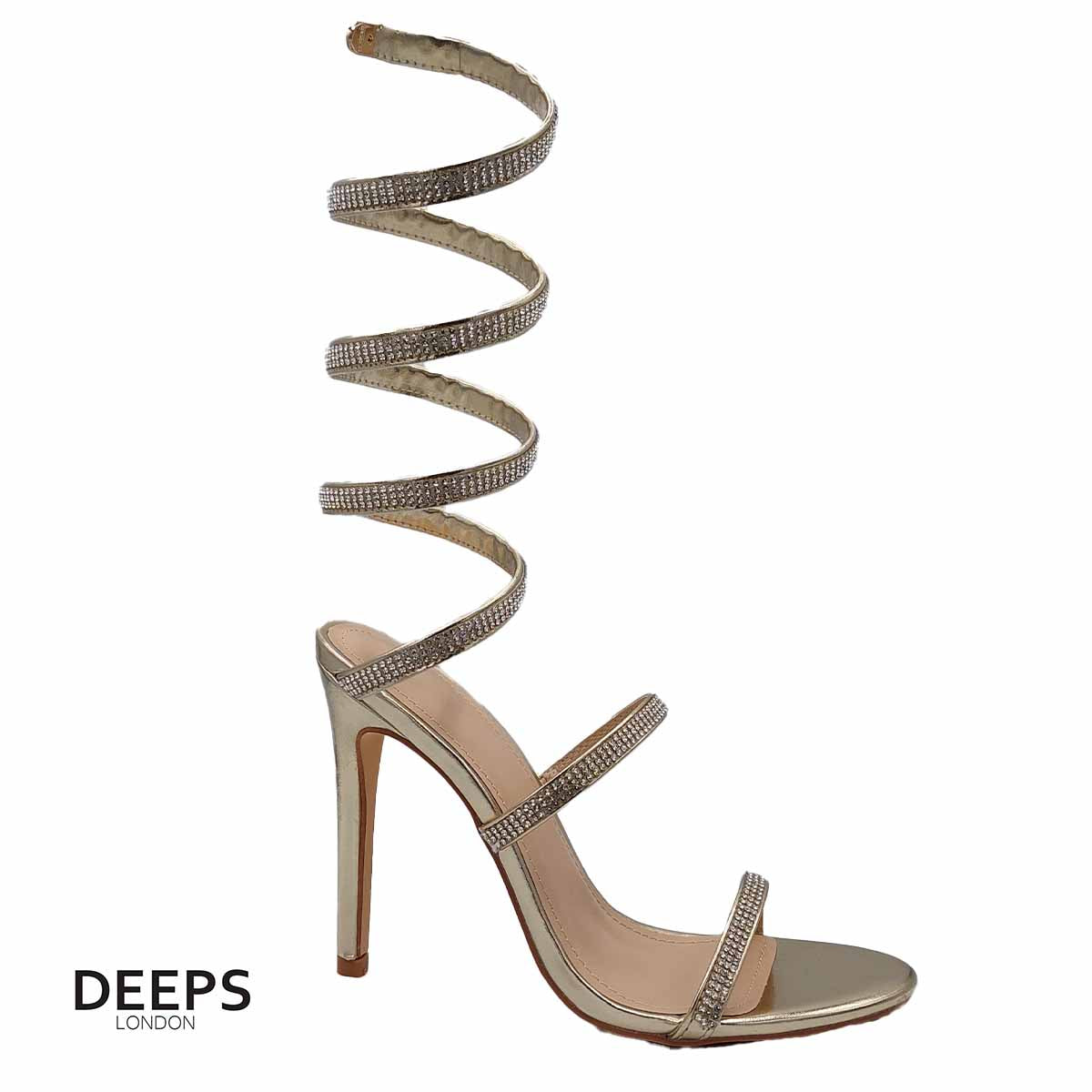 Woman's foot wearing stylish diamante spiral wrap around stiletto heels in gold, a comfortable and fashionable choice for London occasions from DeepsLondon. The spiral wrap is elegantly displayed.