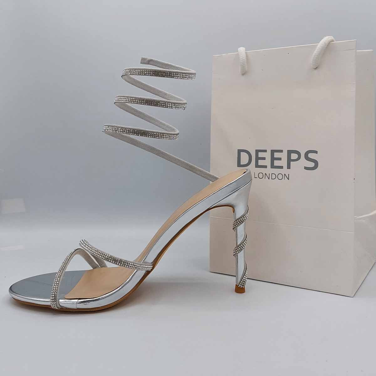 Close-up of the diamante embellishments and spiral wrap strap on stiletto heels in silver, highlighting their elegant and unique design for London events.