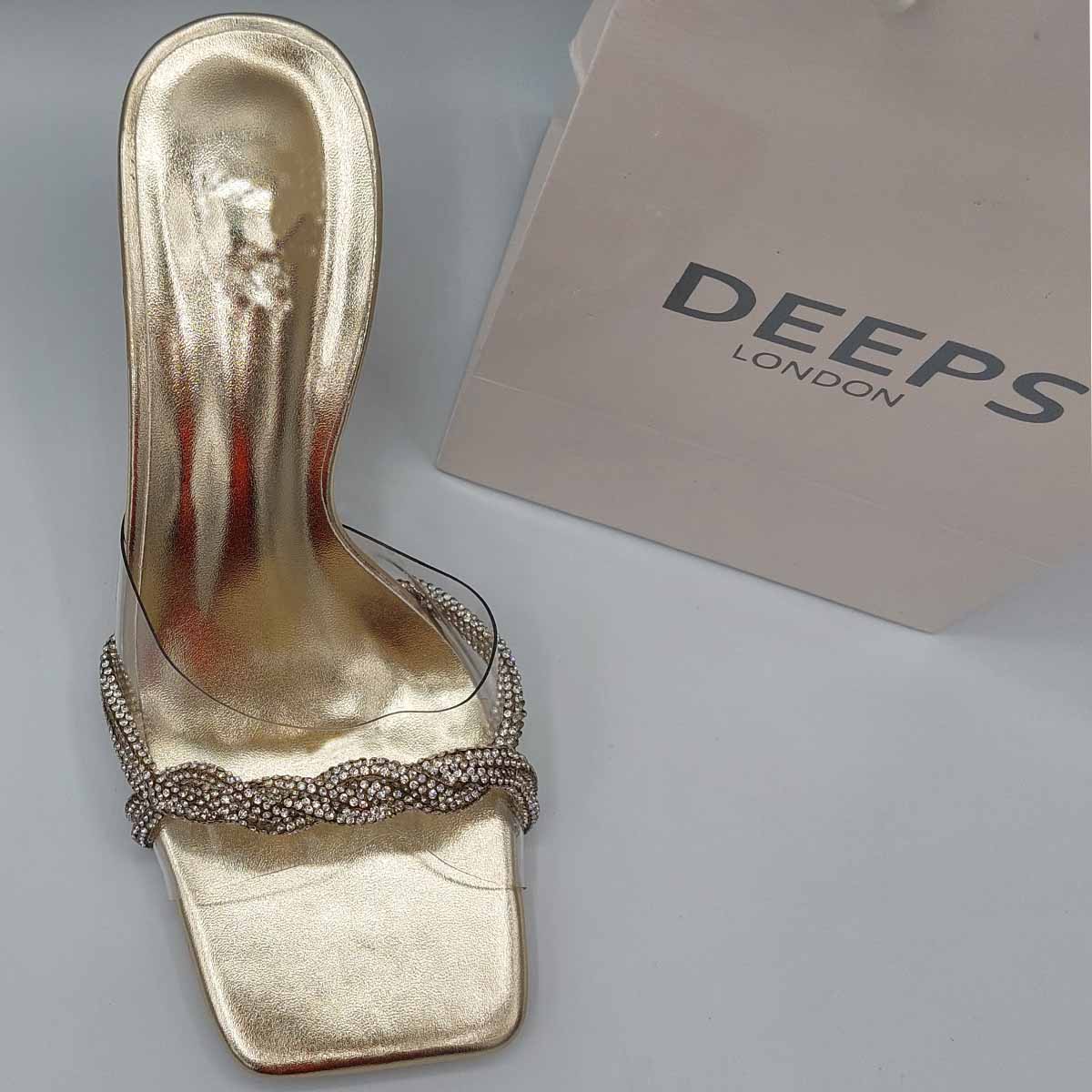 Woman's foot wearing stylish diamante strappy mule sandals in gold, a comfortable and fashionable choice for London evenings from DeepsLondon.