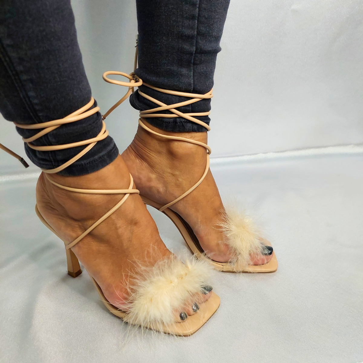 Front view of women's faux fur feather wrap around heel sandals in nude, a glamorous and unique choice for London occasions.