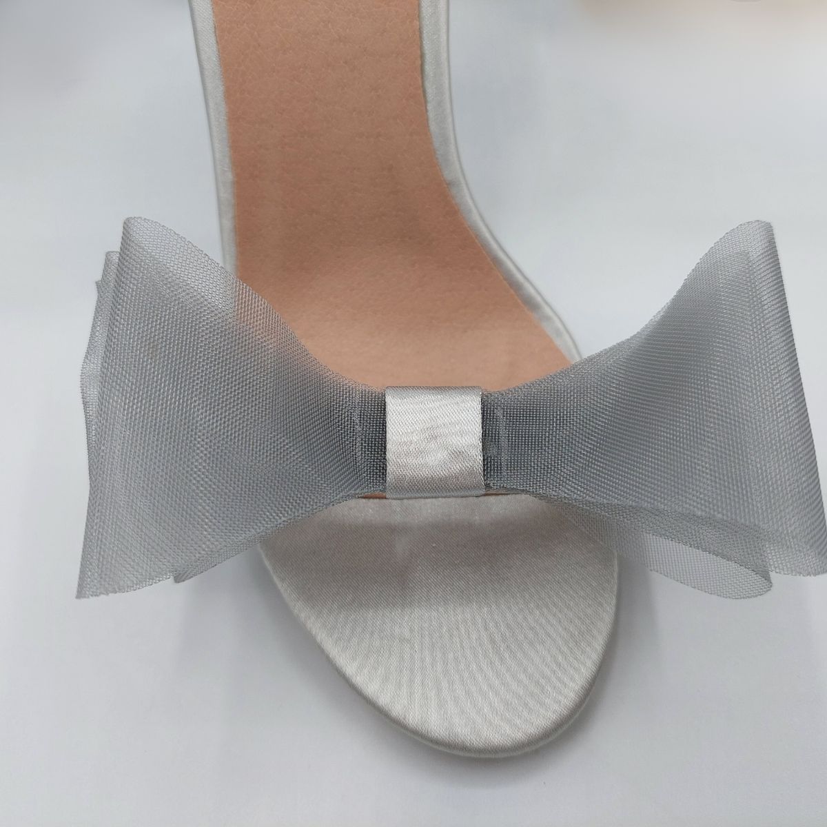 Close-up of the organza bow detail on Majesty high heel sandals in silver satin, showcasing the delicate texture and embellishment, London style from DeepsLondon.