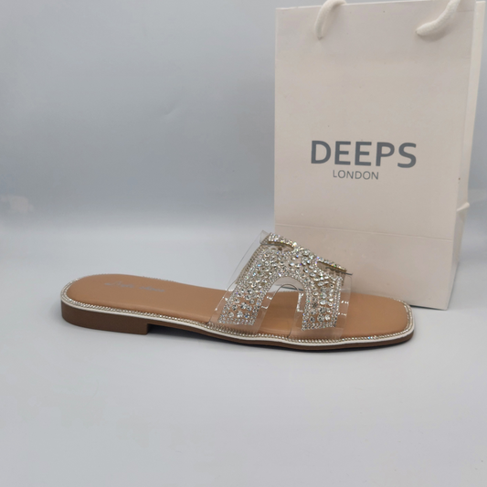 Side view of women's nude flat slip-on sandals with sparkling diamante straps.