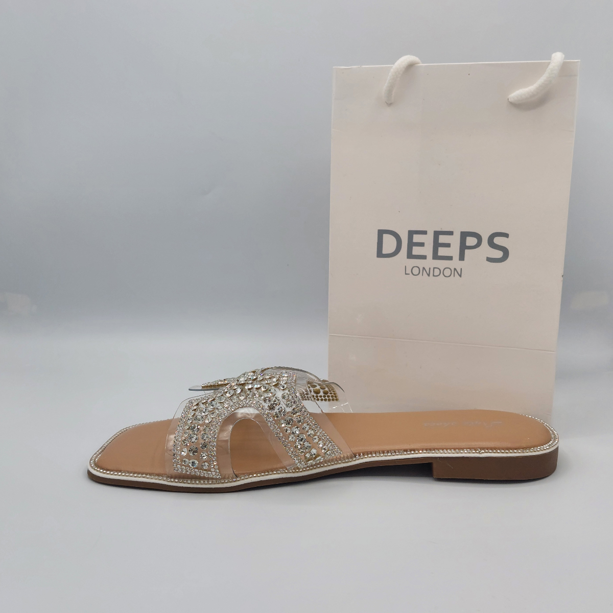 Side profile of women's nude flat slip-on sandals with sparkling diamante straps. party wear shoes