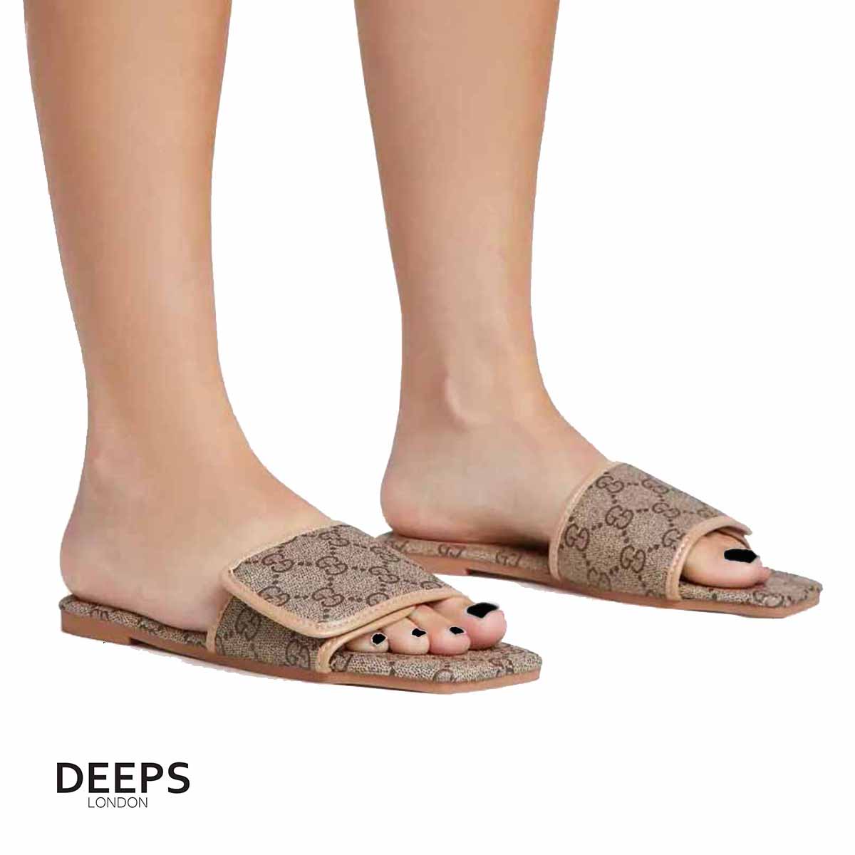 Woman's foot wearing comfortable open toe flat slider sandals with a brown print, a relaxed footwear choice for London life.