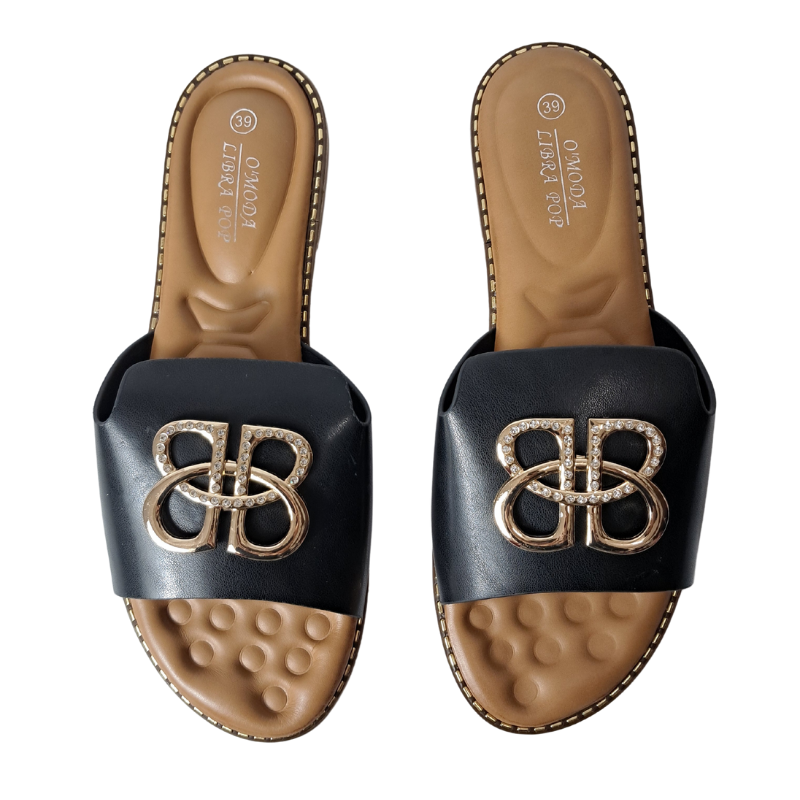 Woman's foot wearing stylish open toe slip-on flat sandal in black, a comfortable and fashionable choice for London days from DeepsLondon.