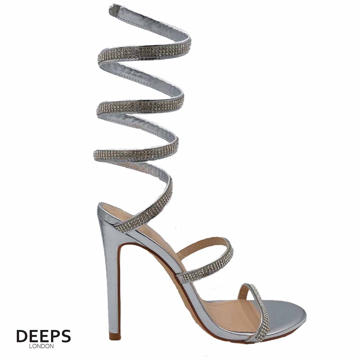Woman's foot wearing stylish diamante spiral wrap around stiletto heels in silver, a comfortable and fashionable choice for London occasions from DeepsLondon. The spiral wrap is elegantly displayed.