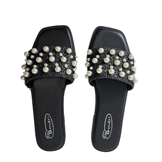Woman's foot wearing stylish open toe pearl studded slip-on slider sandals in black, a comfortable and fashionable choice for London days from DeepsLondon.