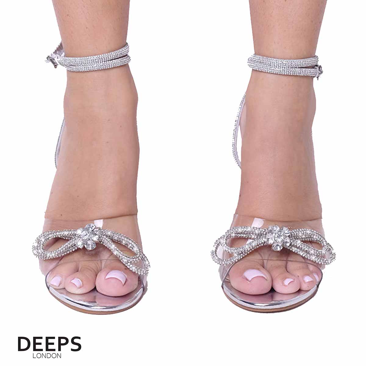 Front view of women's perspex block heel sandal with diamante bow and ankle tie in silver, a trendy and sophisticated choice from DeepsLondon.