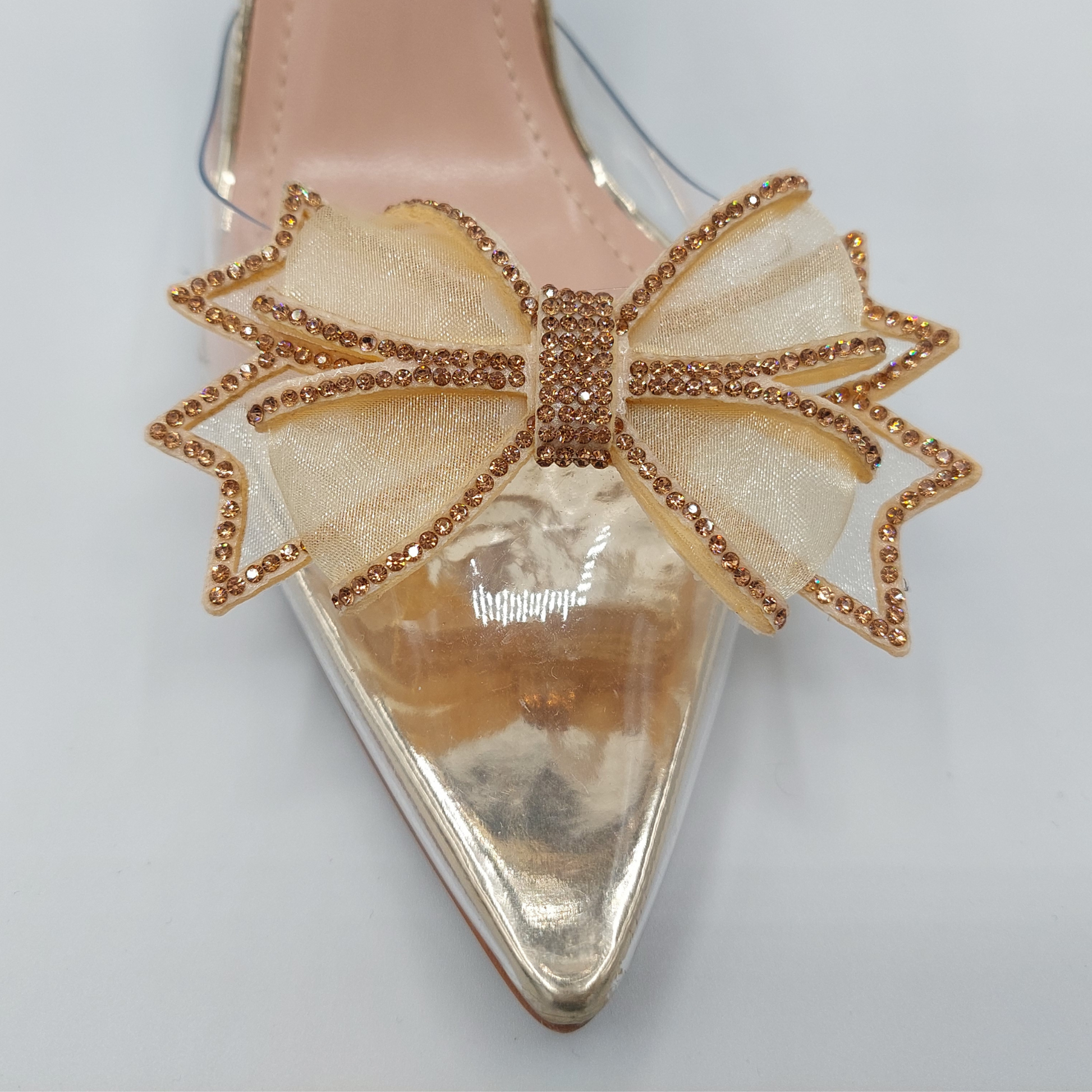 Side profile of women's perspex court shoe with diamante brooch detail in gold, showcasing the perspex material and brooch detailing.