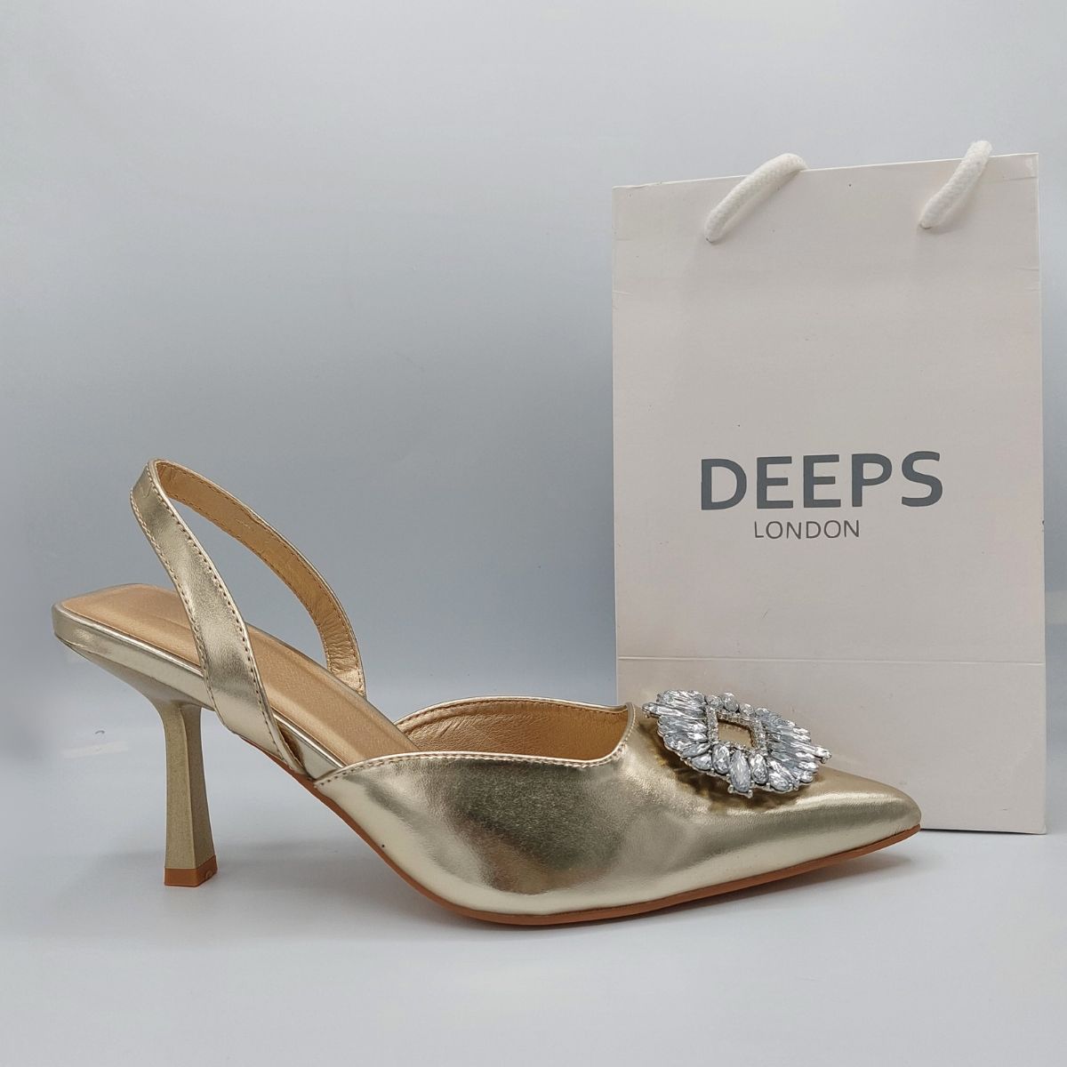Side profile of women's perspex court shoe with diamante brooch detail in Gold PU, showcasing the perspex material and brooch detailing