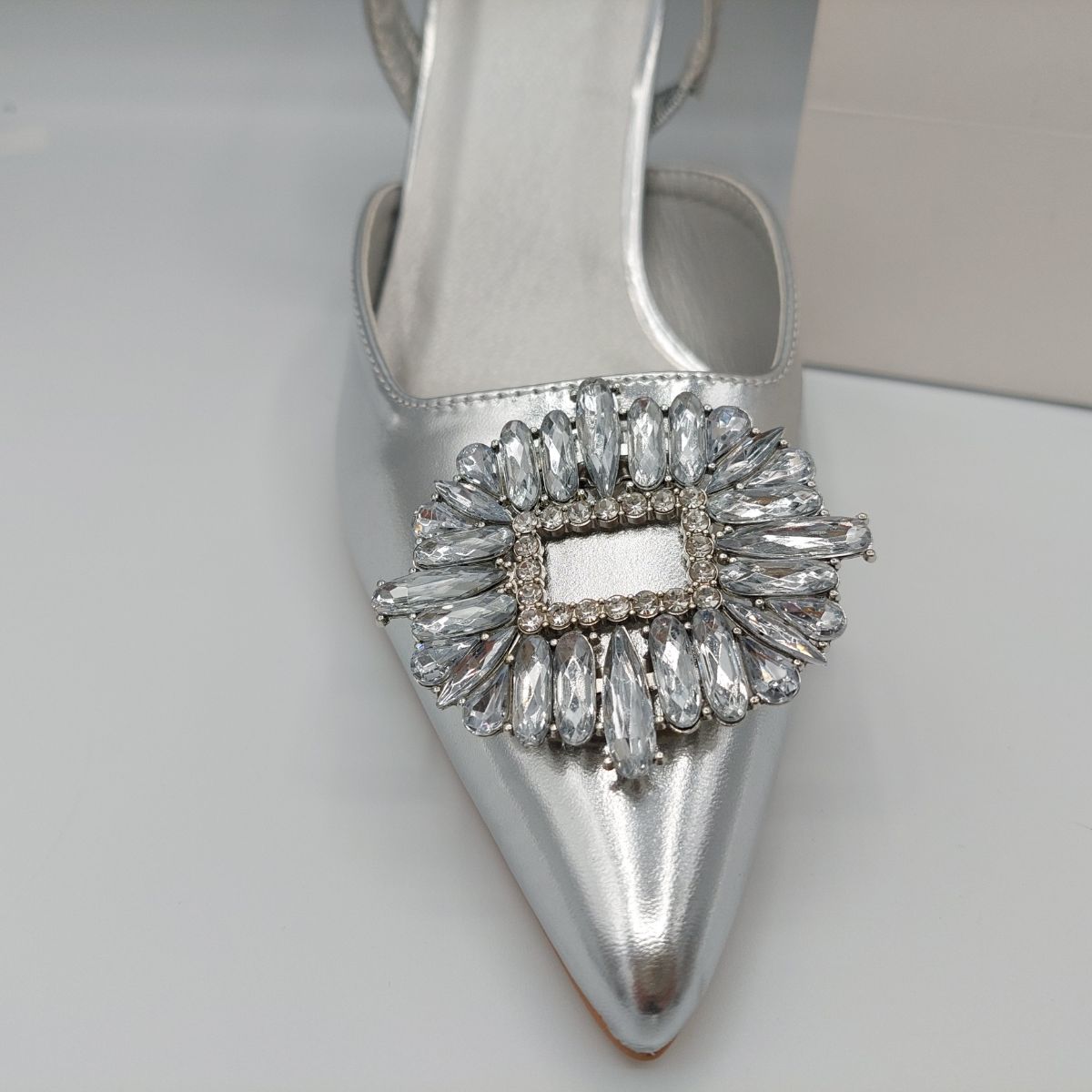 Close-up of the diamante brooch detail on women's perspex court shoe in Silver PU, highlighting its elegant and sparkling features.