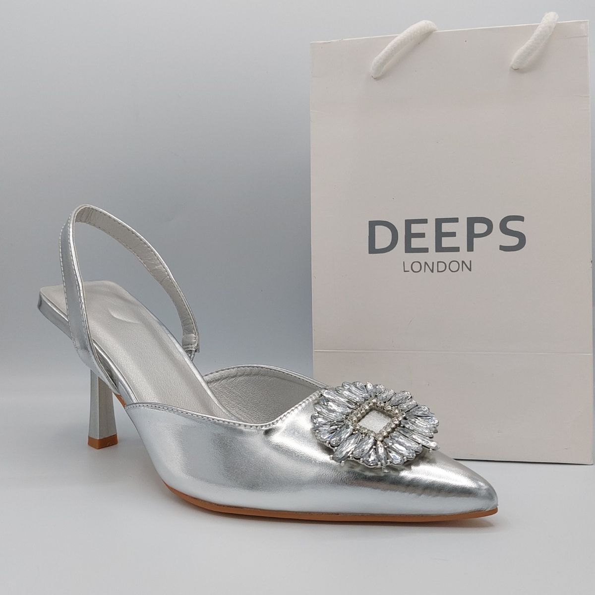Front view of women's perspex court shoe with diamante brooch detail in Silver PU, an elegant and stylish choice for London occasions.