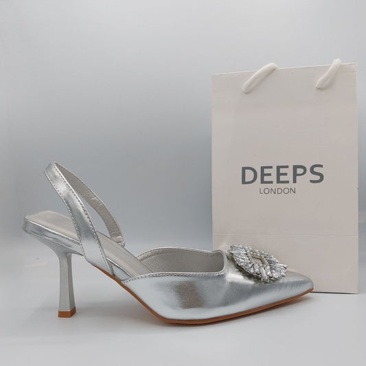 Side profile of women's perspex court shoe with diamante brooch detail in Silver PU, showcasing the perspex material and brooch detailing.