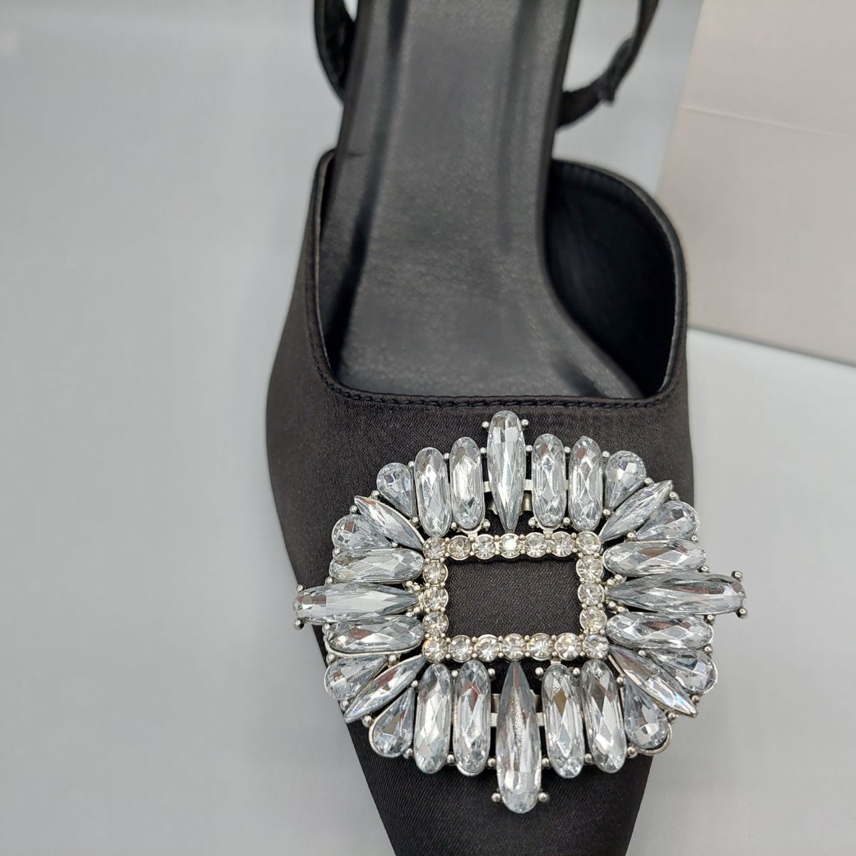 Close-up of the diamante brooch detail on women's perspex court shoe in Black Satin, highlighting its elegant and sparkling features.