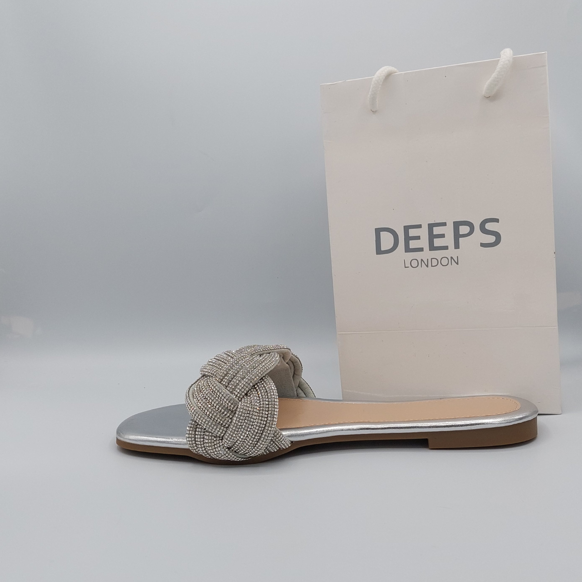 Side profile of silver perspex flat slider sandals for women highlighting the diamante embellishments.