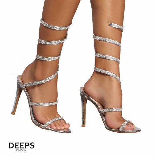 Close-up of the diamante embellishments and spiral wrap strap on stiletto heels in silver, highlighting their elegant and unique design for London events.