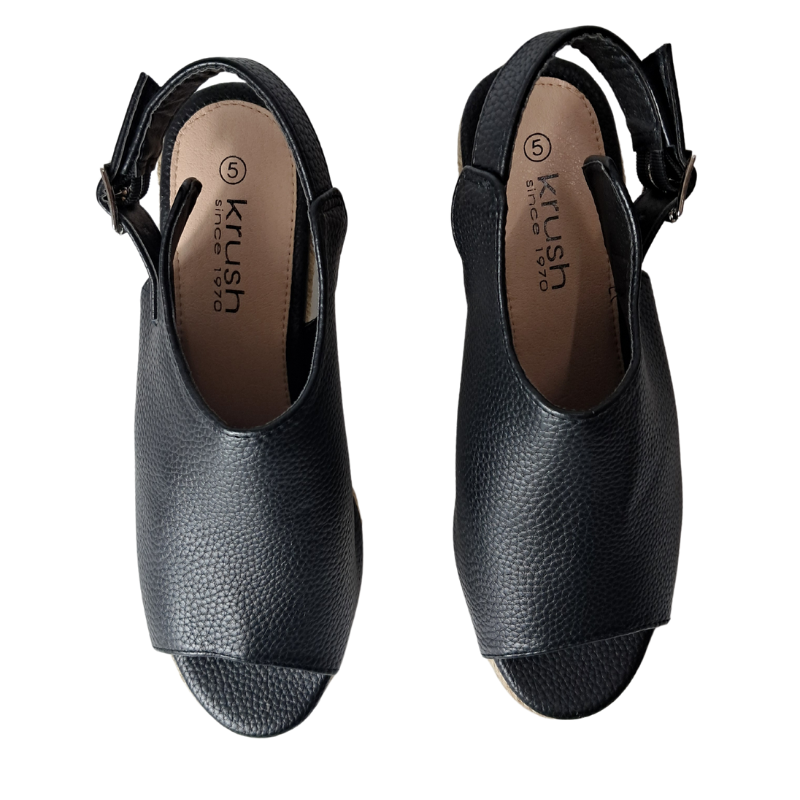 Woman's foot wearing stylish women's wedge heel peep toe sandal in black raffia styles, a fashionable choice for London outings from DeepsLondon.