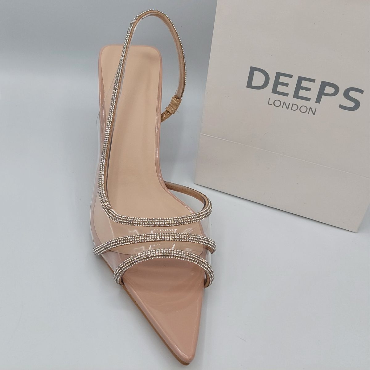 Front view of women's clear perspex slingback stiletto heels with shiny rhinestone embellishments, a glamorous choice for London occasions.