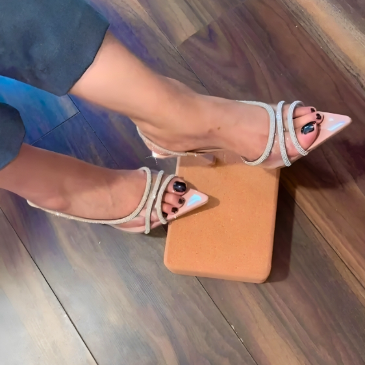 Woman's foot wearing stylish clear perspex slingback stiletto heels with shiny rhinestones, a comfortable and fashionable choice for London events from DeepsLondon.