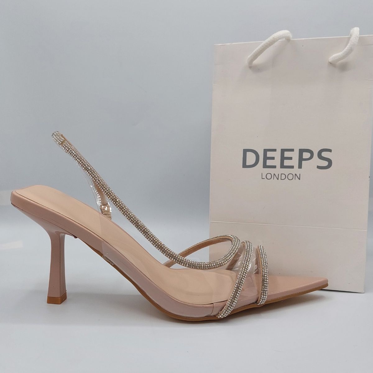 Side profile of women's clear perspex slingback stiletto heels, showcasing the high stiletto heel and rhinestone detailing for London fashion.