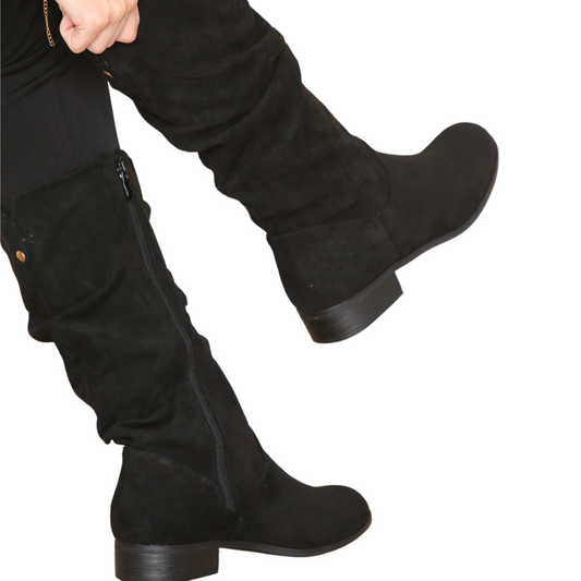 Side profile of women's black suede ruched knee high boots, showcasing the ruched detailing and side zip fastening, perfect for London fashion.