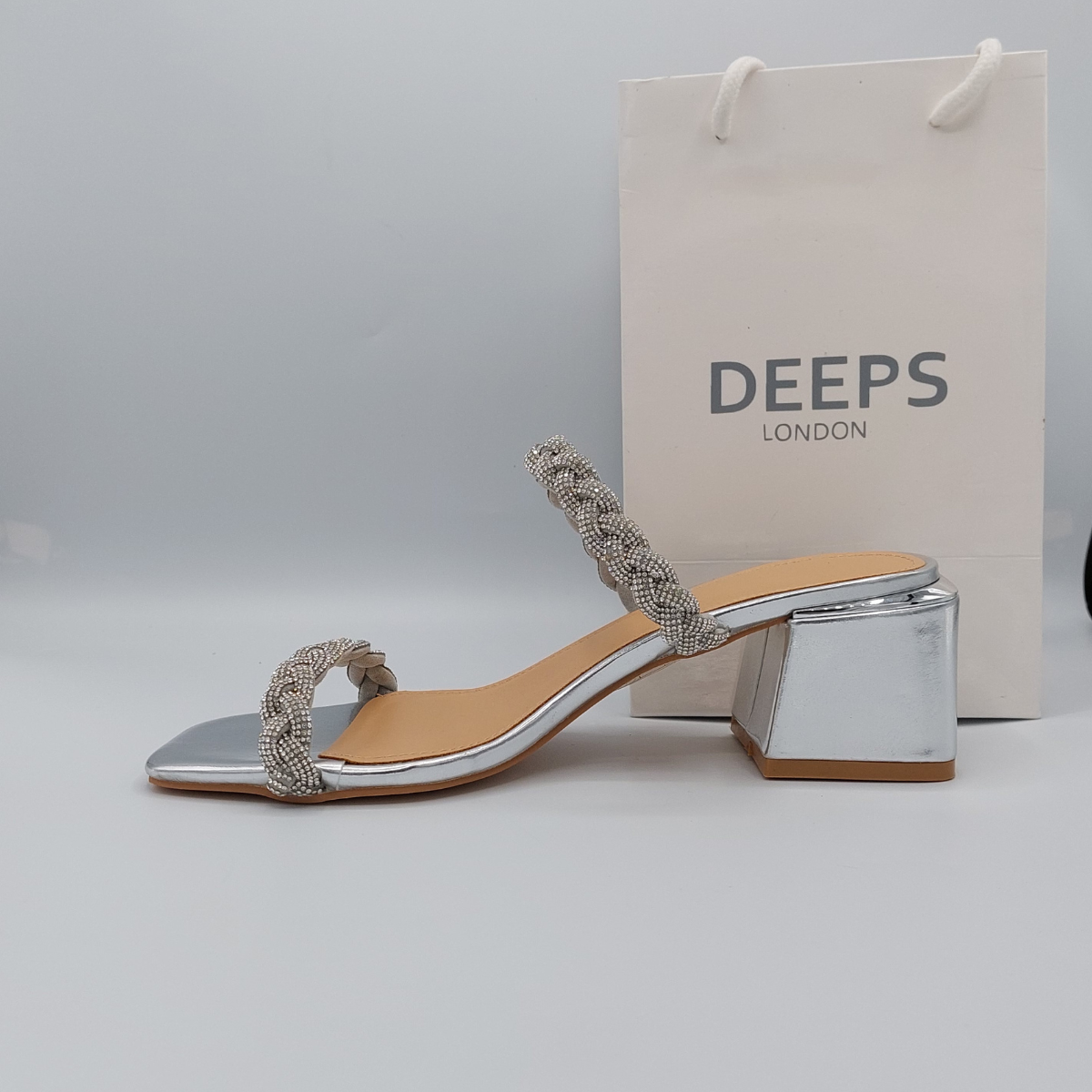 Close-up of the silver plaited strap and gemstone detailing on Deeps London block heel mule, highlighting their elegant and sparkling features.
