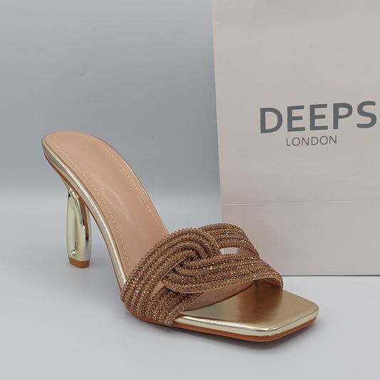 Side profile of women's strappy embellished mule heel sandals in gold, showcasing the embellished straps and heel for London fashion.