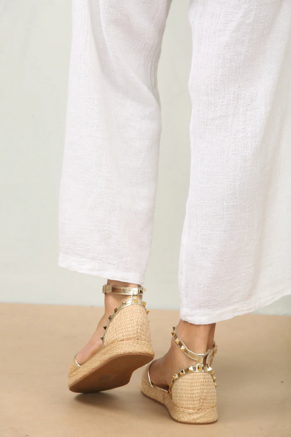 back profile of the stud details and raffia texture on studded ankle strap sandals in gold, showcasing the unique embellishments, London boho-chic footwear from DeepsLondon.