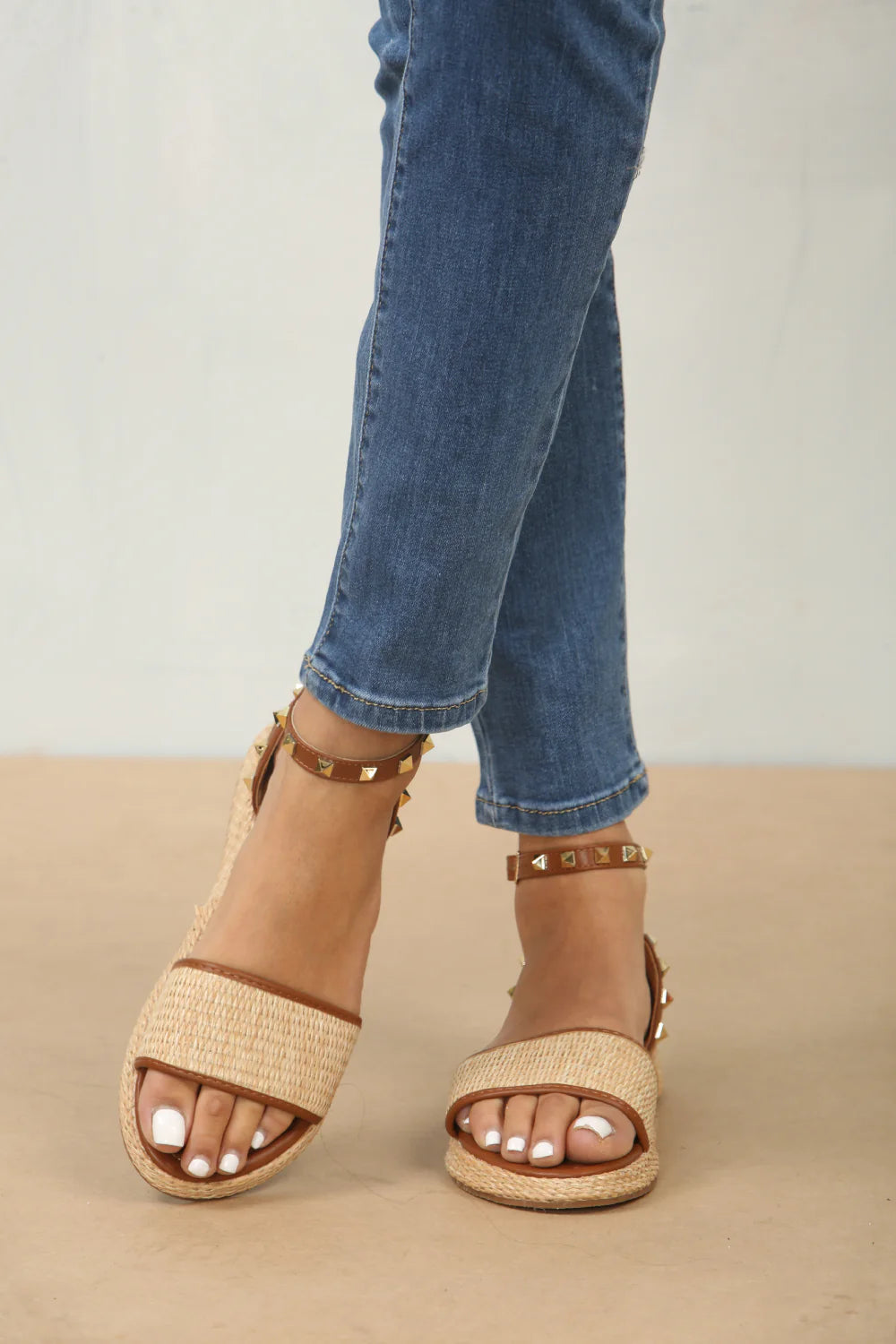 Front view of studded raffia closed back ankle strap sandals in tan, showcasing the stylish raffia texture and subtle stud details, London boho-chic style from DeepsLondon.