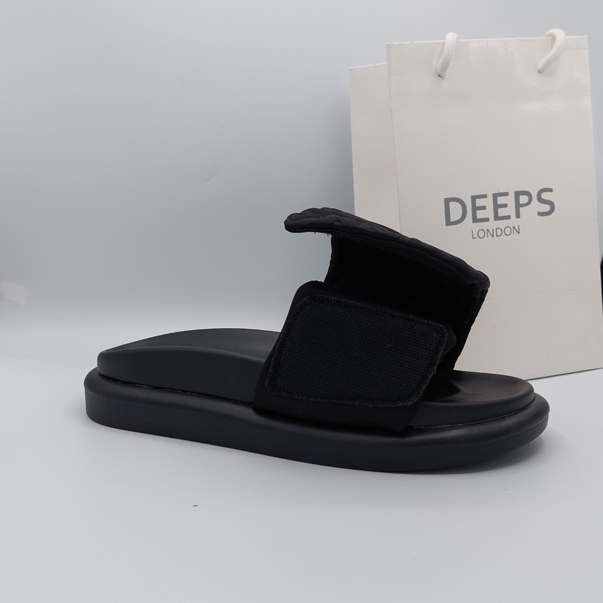 Close-up of the velcro straps and flatform sole on women's slider sandal in black, emphasizing the comfort and adjustability.