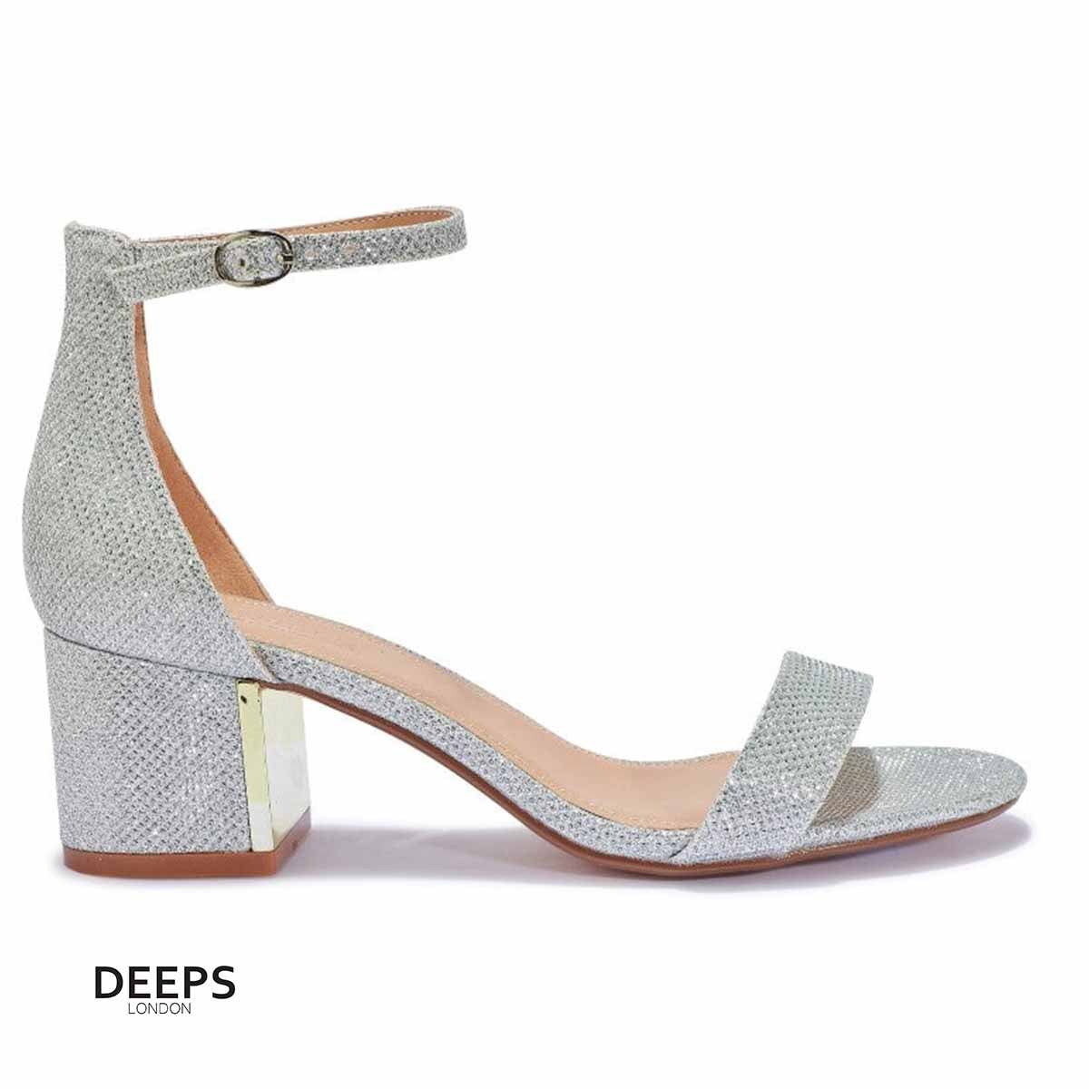 Side profile of women's Stravelle block heel buckle strap sandals in silver shimmer, showcasing the block heel and buckle strap detailing for London fashion.