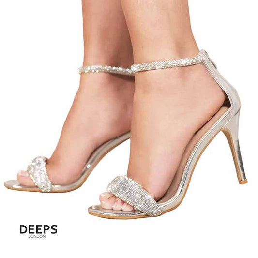 Woman's foot wearing stylish Beatrice stiletto heeled sandal with diamante detailed strap in silver metallic, a fashionable and glamorous choice for London events from DeepsLondon.
