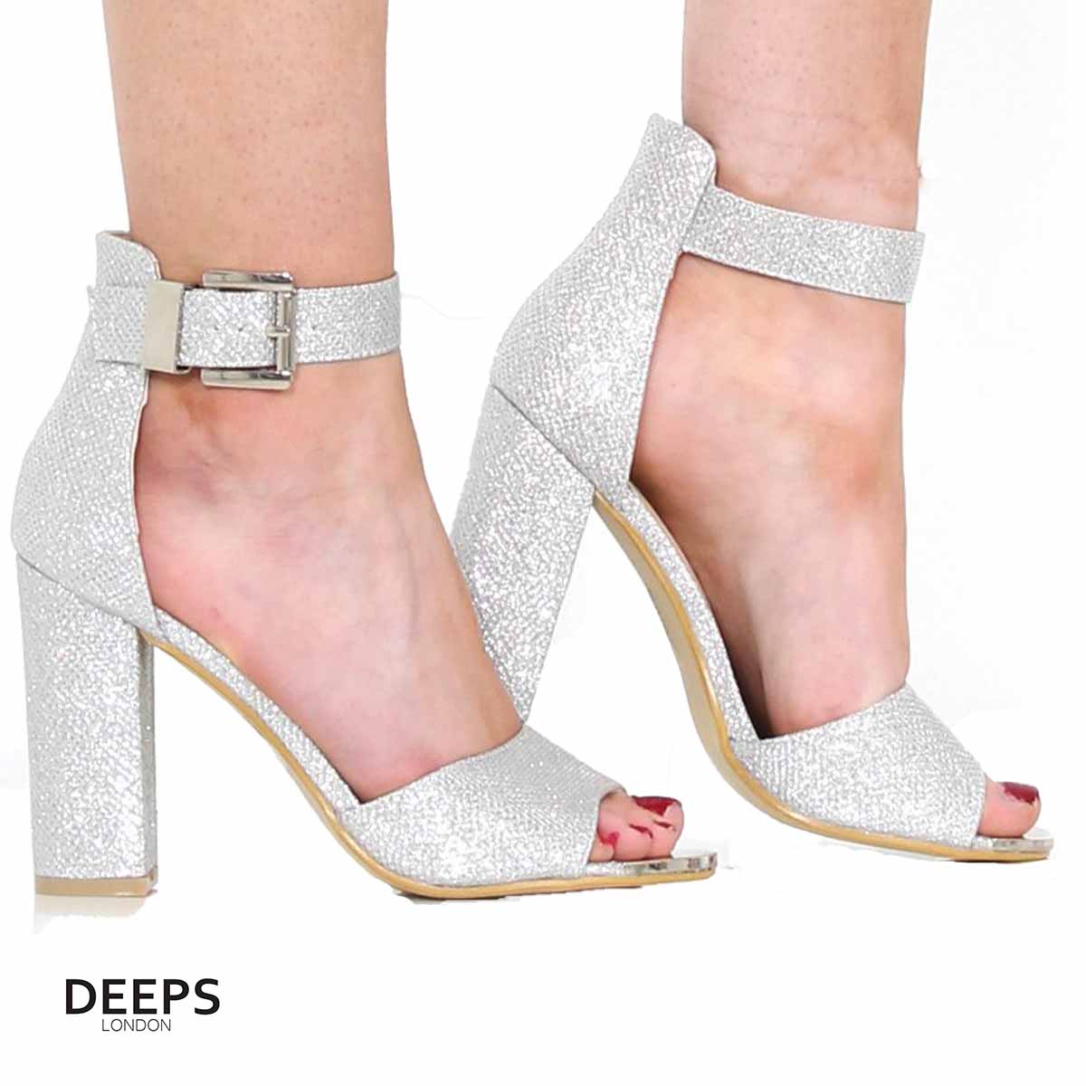 Woman's foot wearing stylish Belgravia chunky buckle strap block heel sandals (approx. 4-inch heel) in Silver side, a fashionable and confident choice for London events from DeepsLondon.