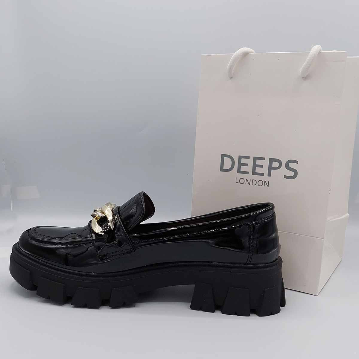Close-up of the chunky platform sole and the bold chain detail on women's black patent loafers, highlighting their unique and fashionable features in London.