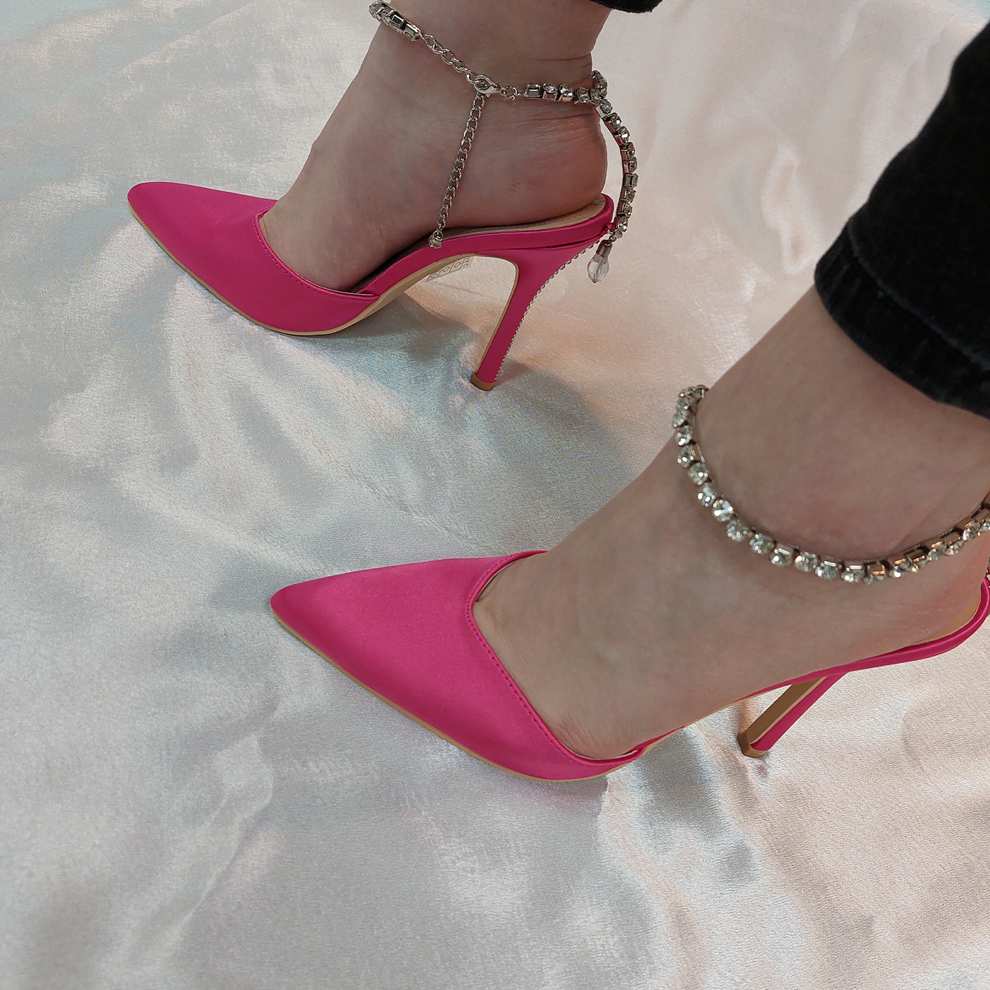 Woman's foot wearing stylish Celestial satin court shoes with diamante ankle chain in fuchsia, a fashionable choice for London events from DeepsLondon.