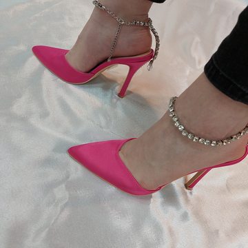 Woman's foot wearing stylish Celestial satin court shoes with diamante ankle chain in fuchsia, a fashionable choice for London events from DeepsLondon.