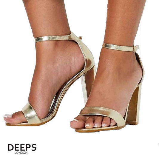 Woman's foot wearing stylish chunky buckle strap block heel sandals (approx. 9.5cm heel) in gold, a fashionable and confident choice for London events from DeepsLondon.