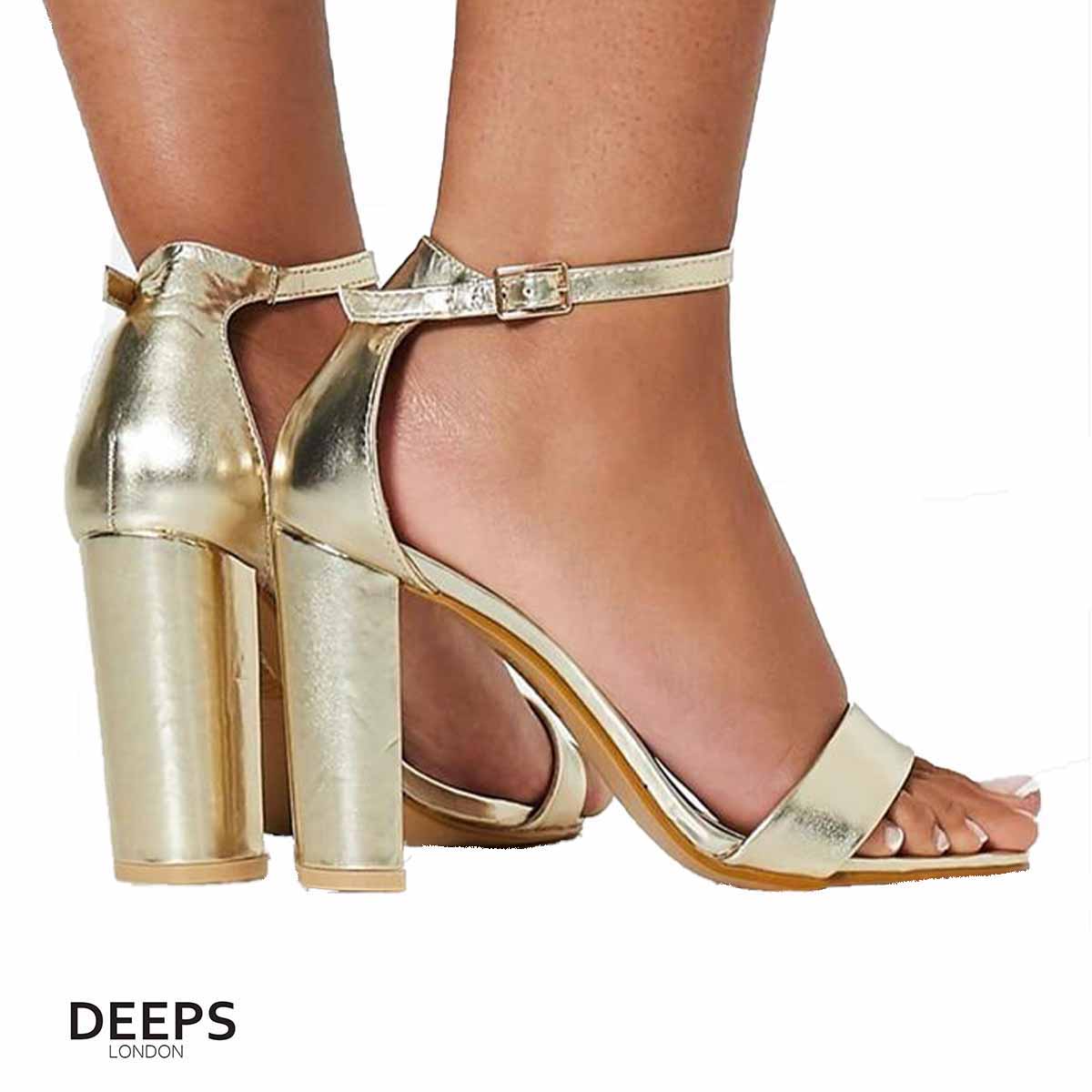 Woman's foot wearing stylish chunky buckle strap block heel sandals (approx. 9.5cm heel) in gold, a fashionable and confident choice for London events from DeepsLondon.