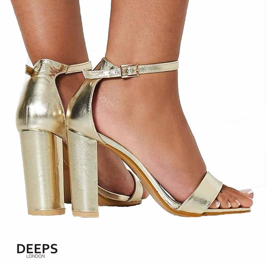 Woman's foot wearing stylish chunky buckle strap block heel sandals (approx. 9.5cm heel) in gold, a fashionable and confident choice for London events from DeepsLondon.
