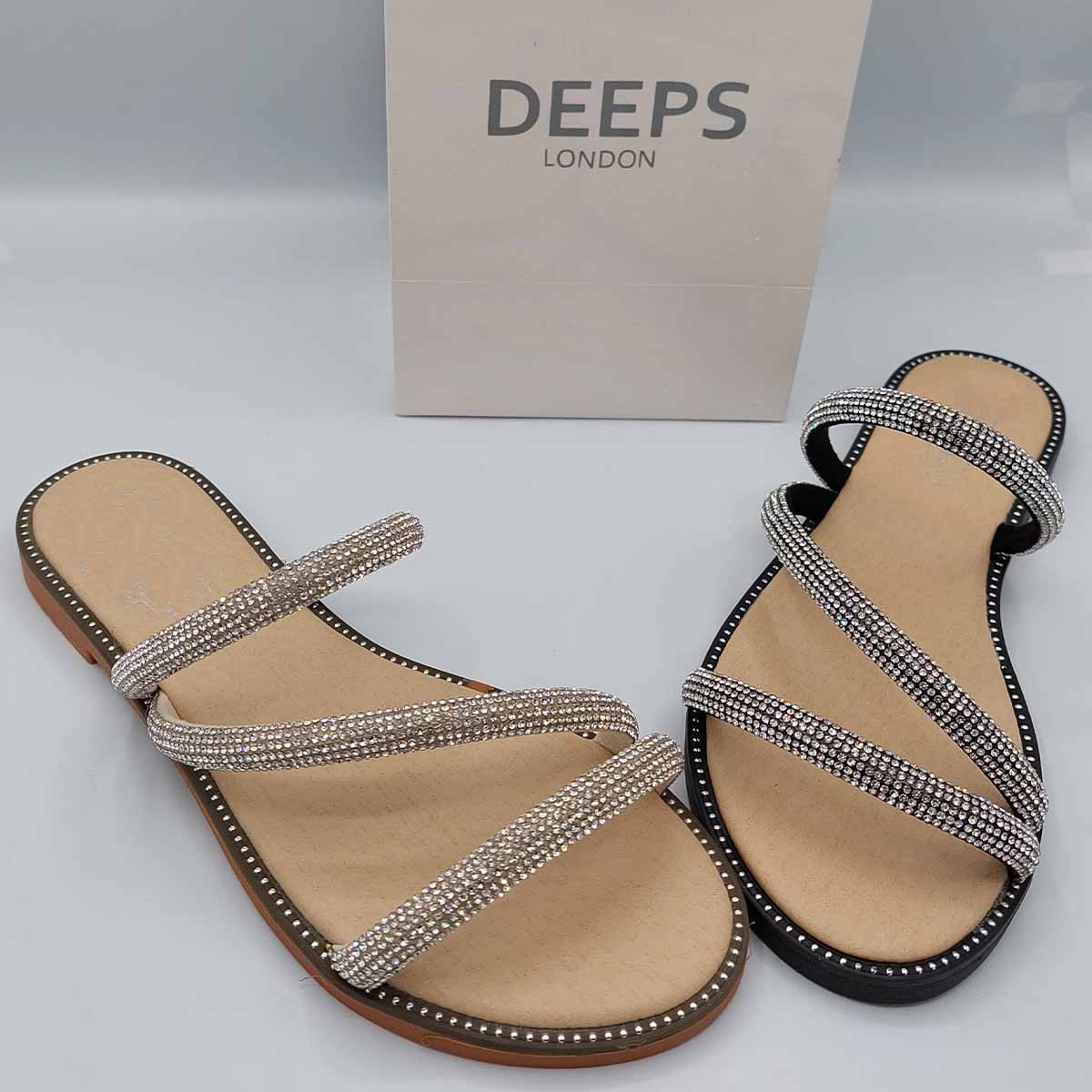 Front view of women's cross strap flat slider sandals in black and beige with sparkly embellishments, a glamorous choice for London.