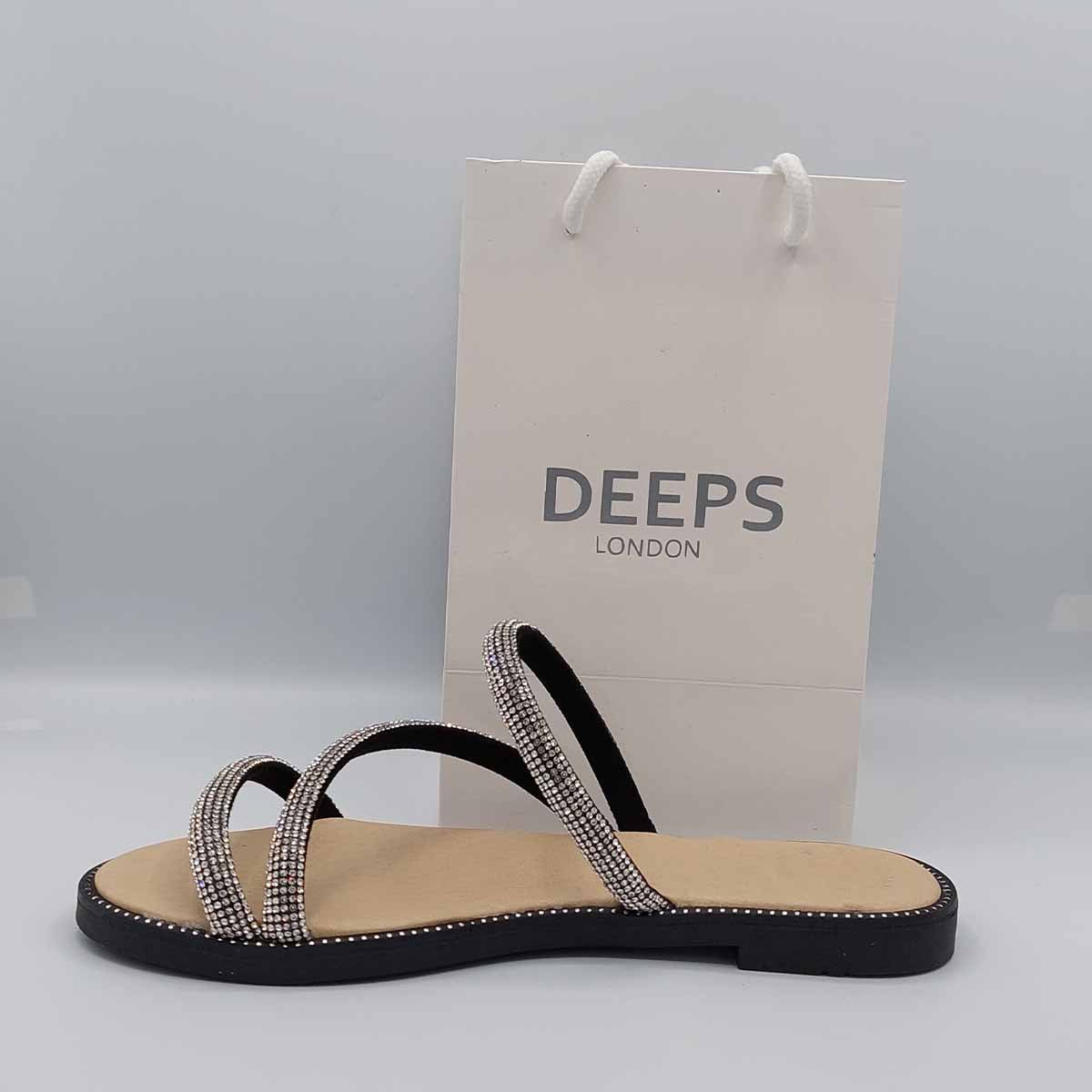 Woman's foot wearing stylish cross strap embellished flat slider sandals in black, a comfortable and fashionable choice for London life from DeepsLondon.