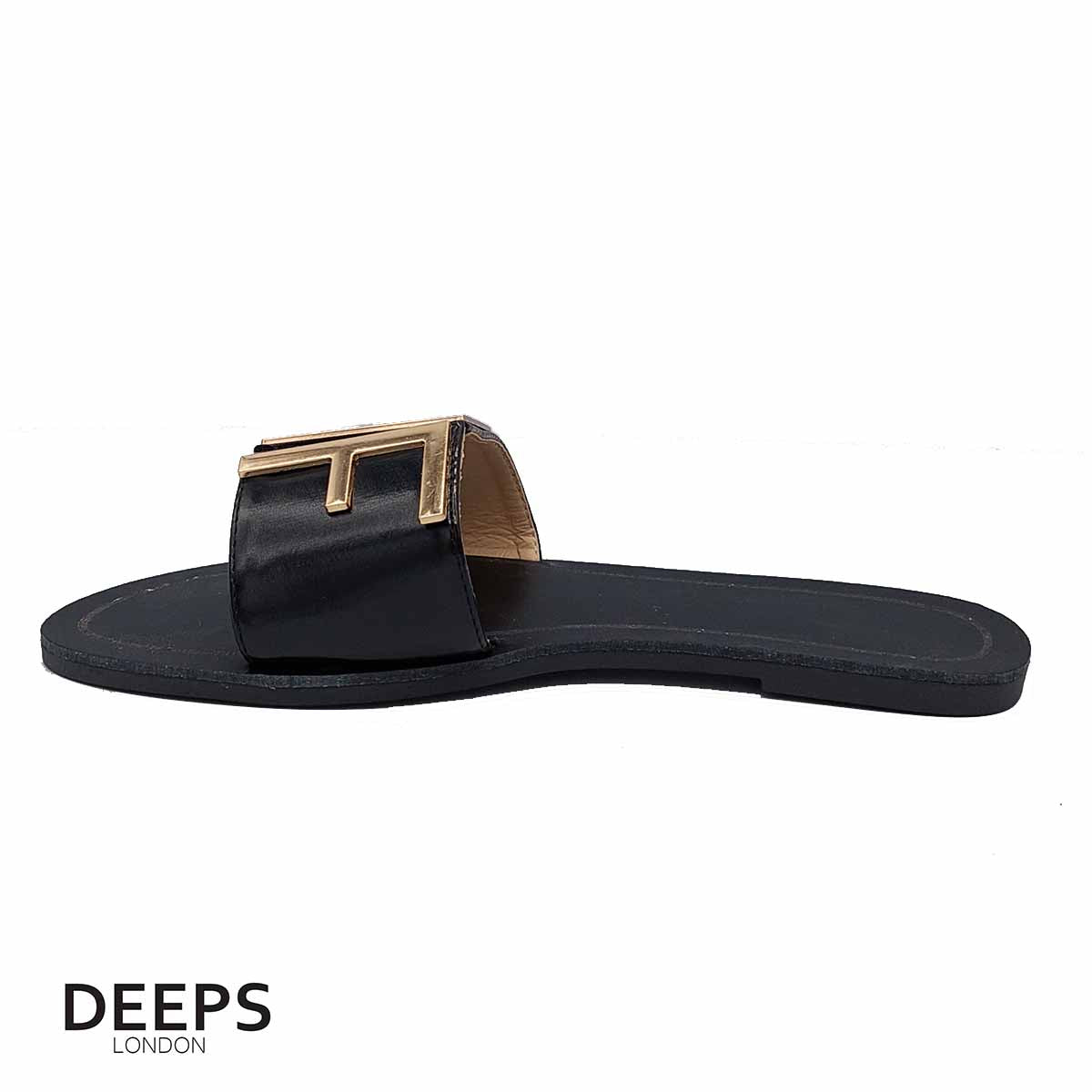 Close-up of the gold bar detail on women's black open toe flat slider sandals, highlighting their subtle elegance for London style.