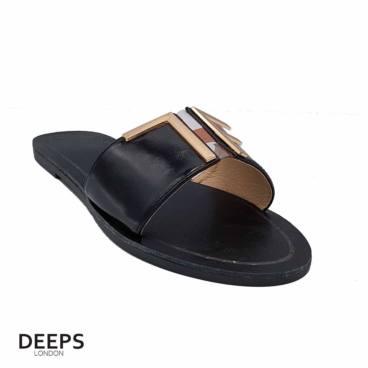 Side profile of women's black open toe flat slider sandals featuring a gold bar detail, showcasing their easy slip-on style for London comfort.